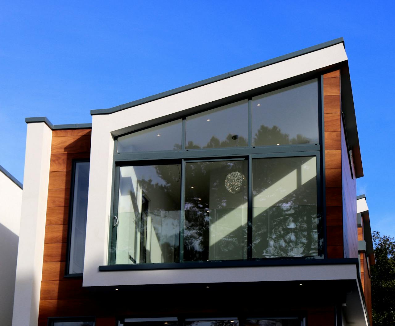 services-03 Contemporary house in Poole, UK featuring a sleek design with large glass windows and wood paneling.