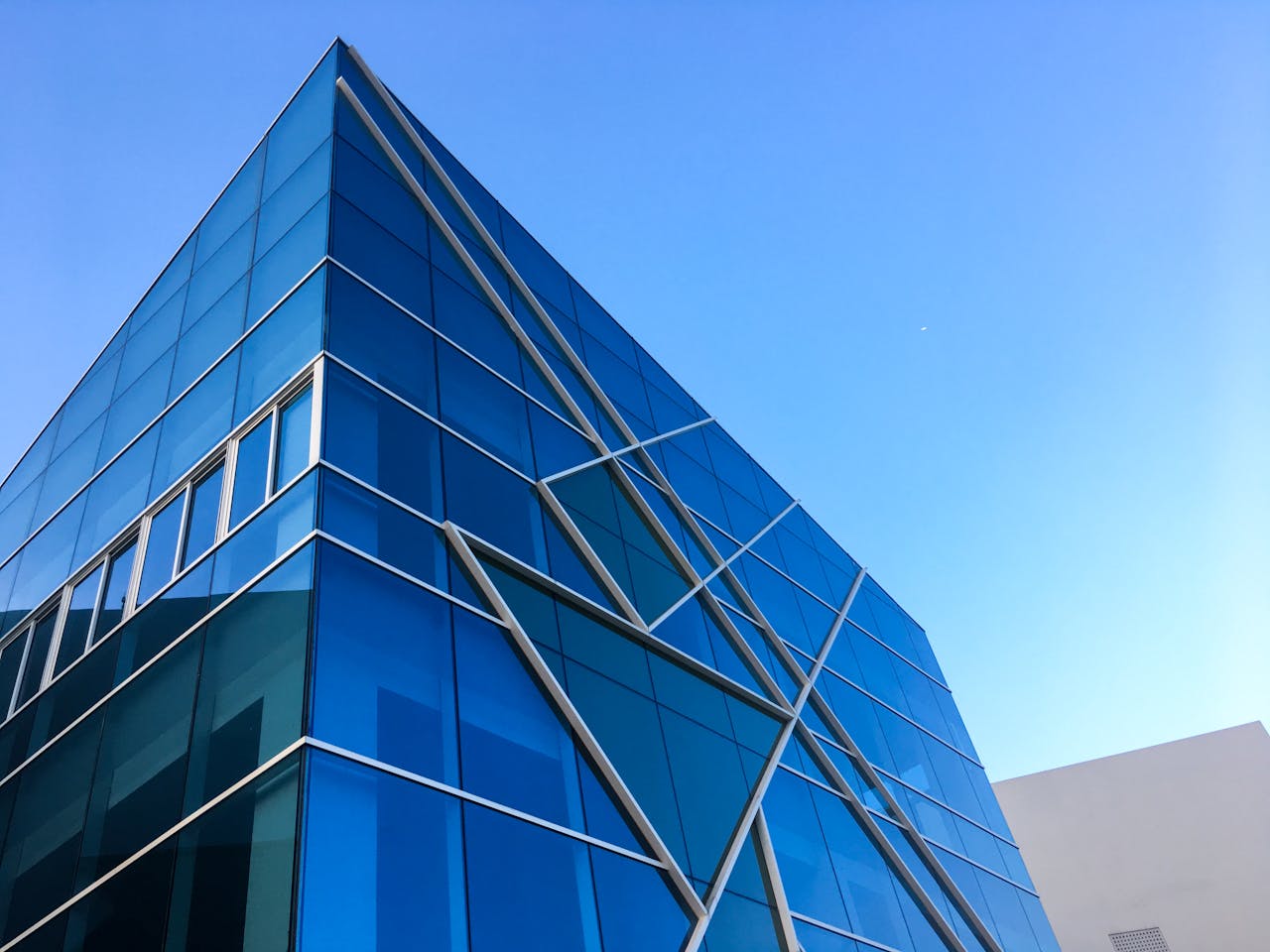 why-choose-us Striking blue glass building against a clear sky in Hải Châu, Vietnam.